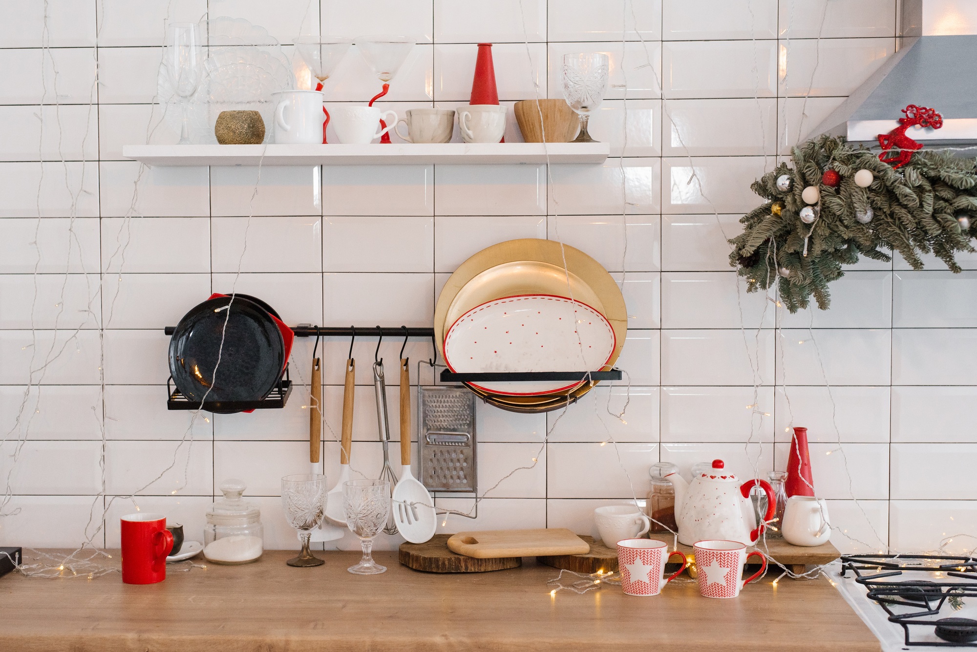 White festive kitchen - tiles on the wall, red decor elements. Christmas home